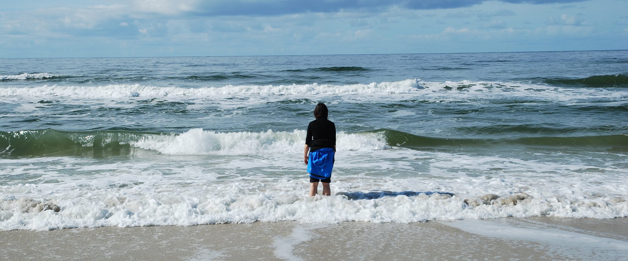 Foto weiter Blick aufs Meer. Ich stehe mit dem Rücken zur Kamera mit den Füßen im Meer.